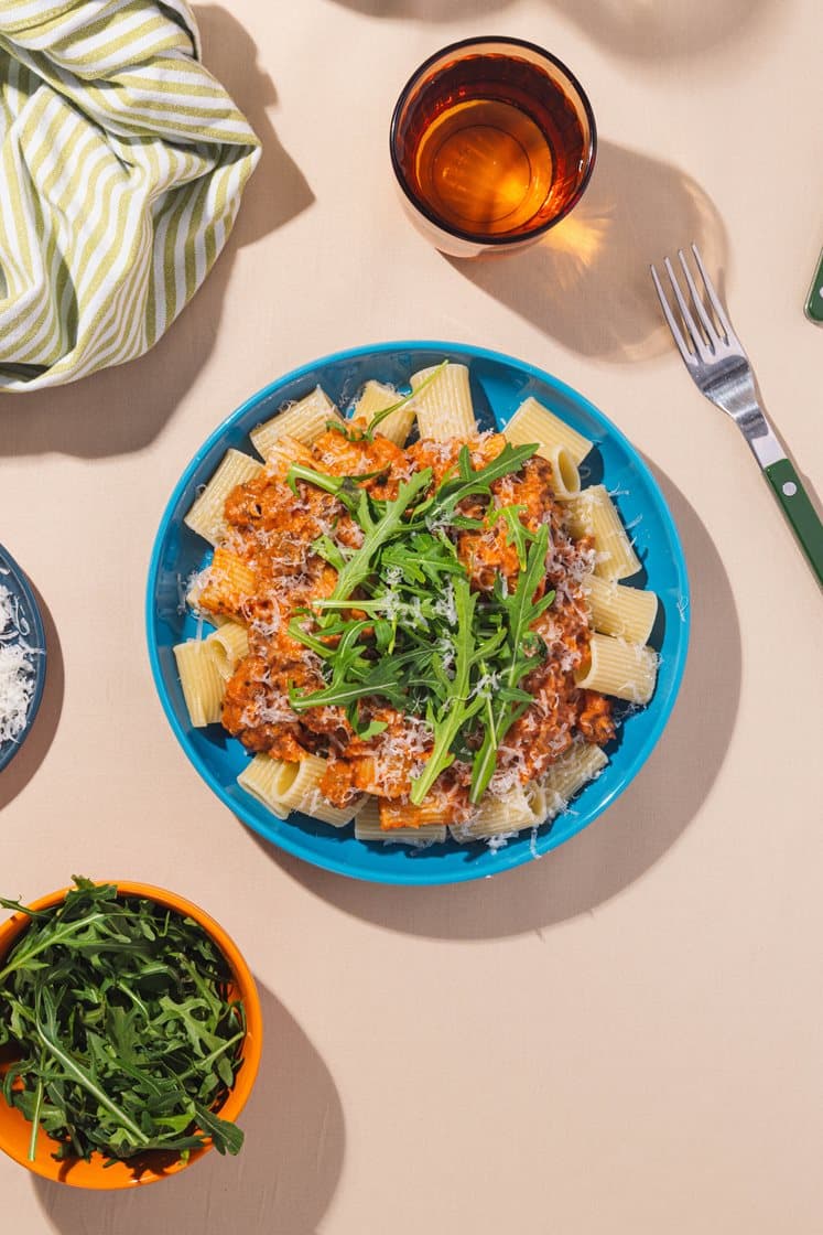 Pastagryte med kremet tomat- og kjøttsaus og ruccolasalat