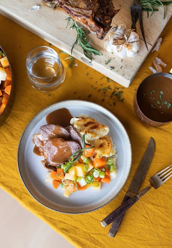 Langtidsstekt lammelår med hvitløk og rosmarin, med fløtegratinerte poteter, glaserte rotgrønnsaker og rødvinssaus