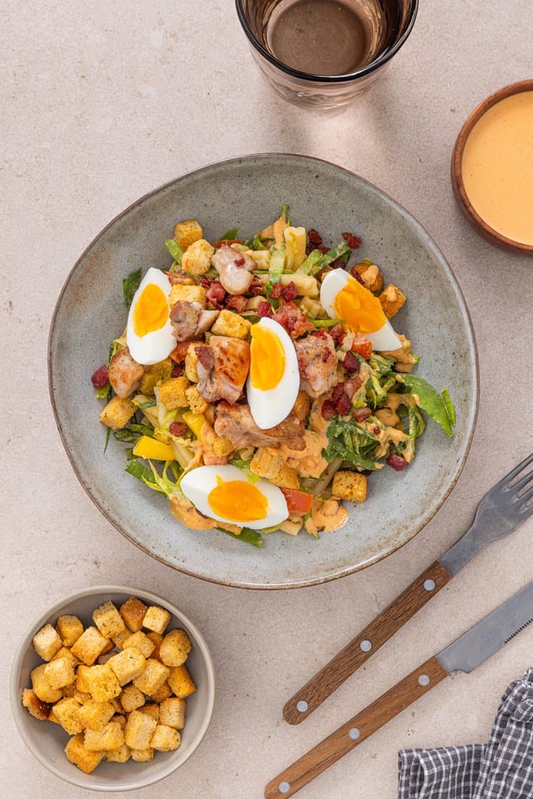Pastasalat med stekt kylling og bacon, paprikapestodressing, bløtkokte egg og urtekrutonger