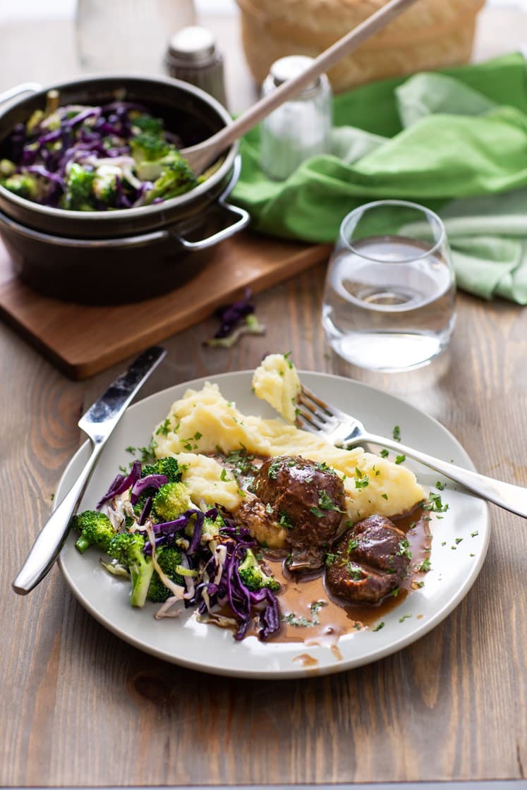Mørkokte svinekjaker i soppsjy med rødkål, brokkoli og potetmos