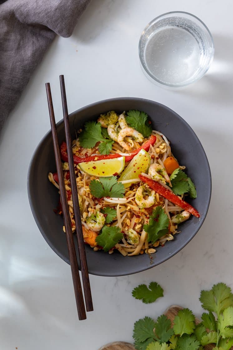Pad thai med håndpillede reker og eggnudler, servert med bønnespirer, peanøtter og koriander