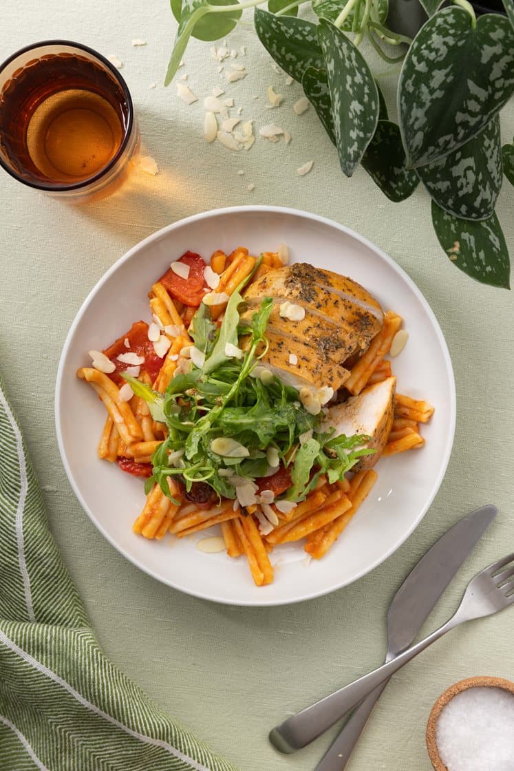 Pasta i romescosaus med kyllingfilet, ruccola og mandler