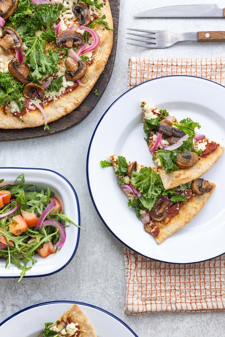 Fullkornspizza med skjørost, sprø grønnkål, sopp, og syltet rødløk