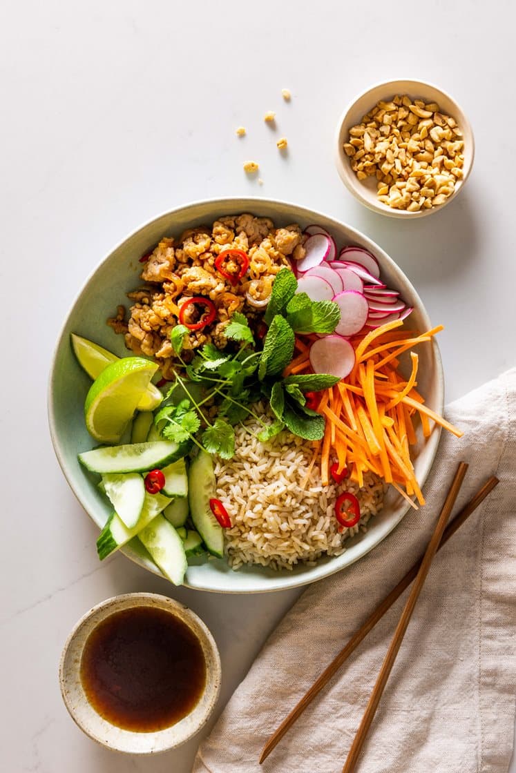 Vietnamesisk ricebowl med kyllingkjøttdeig og friske grønnsaker, servert med mynte og hakkede peanøtter