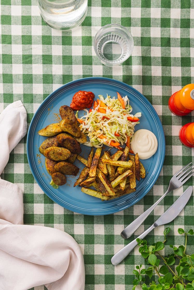 Potetfries med karriwurst, to sauser og syltet kål- og paprikasalat